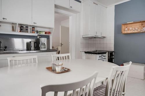 cocina blanca con mesa blanca y sillas en Rustic home surrounded by forest in Skellefteå en Skellefteå