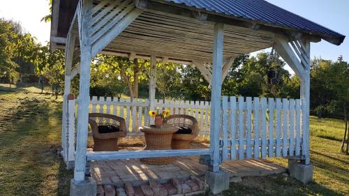 a blue gazebo with three baskets and a fence at Apartman Barbara in Daruvar