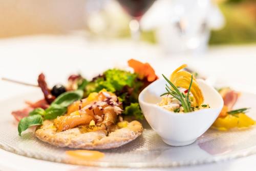 a plate of food with a salad and a bowl of food at Schönenberger Hof in Orsingen-Nenzingen
