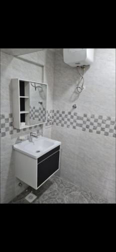 a bathroom with a sink and a mirror at Ad apartment in Kwedonu
