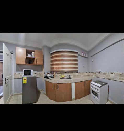 a large kitchen with a sink and a stove at Ad apartment in Kwedonu