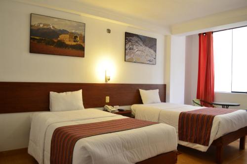 ein Hotelzimmer mit 2 Betten und einem Fenster in der Unterkunft Viandina Machupicchu in Machu Picchu