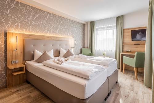a hotel room with a large bed and a desk at Schönenberger Hof in Orsingen-Nenzingen