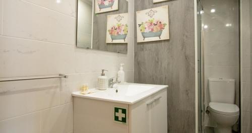 bagno bianco con lavandino e servizi igienici di Casa do Recanto - Loft vista rio a Porto