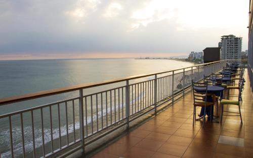 曼塔的住宿－曼塔霍斯特酒店，一个带椅子的阳台,享有海滩美景
