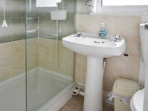 a bathroom with a sink and a shower and a toilet at Sandy Toes in Scratby