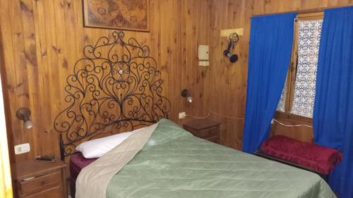 1 dormitorio con cama y cortina azul en Cabaña Uspallata, Mendoza. Para 4 personas en Uspallata