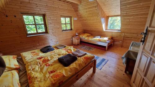 a bedroom with two beds in a log cabin at Chata Bobrovecká vápenica in Bobrovec