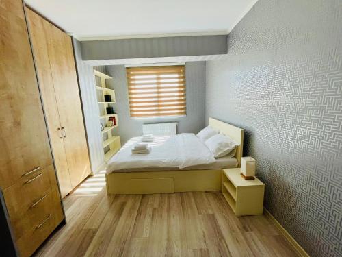 um pequeno quarto com uma cama e uma janela em Olive Apartament em Iaşi