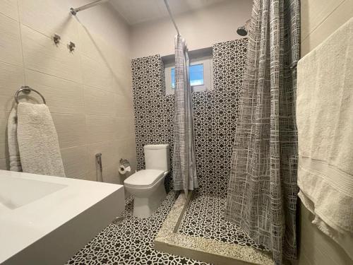y baño con aseo blanco y ducha. en Silk Route Lodge en Gulmit