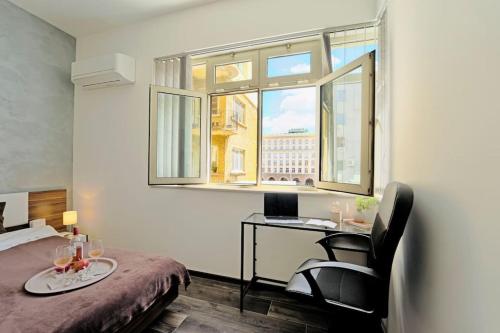 una camera con letto e scrivania con computer portatile di Cozy 2-Bedroom Flat in the very Center of Sofia a Sofia