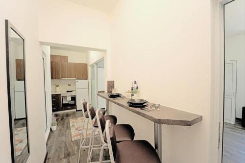 a kitchen with a bar with chairs and a table at Cozy 2-Bedroom Flat in the very Center of Sofia in Sofia
