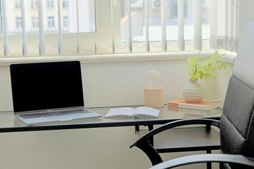 a laptop computer sitting on a desk with a chair at Cozy 2-Bedroom Flat in the very Center of Sofia in Sofia