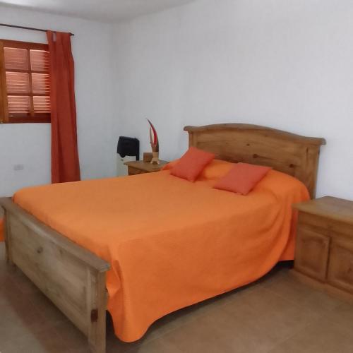 1 dormitorio con 1 cama grande con manta naranja en CASA FRANCISCO en Córdoba