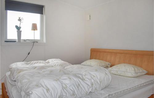 uma cama não feita num quarto com uma janela em Nice Home In Tyringe With Lake View em Tyringe
