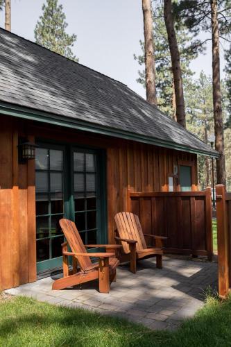 two chairs sitting on a patio in front of a cabin at FivePine Lodge in Sisters