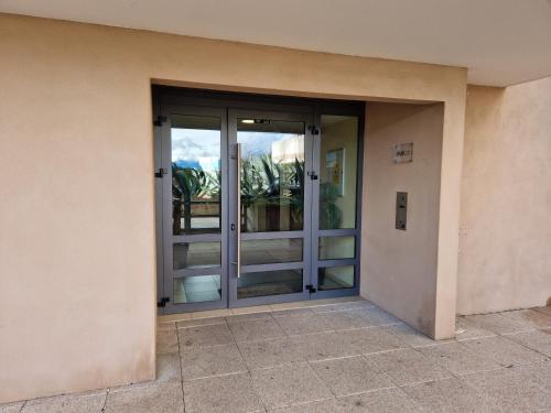 una entrada a un edificio con puertas de cristal en Studio cosy proche toutes commodités avec parking gratuit, en Mezzavia