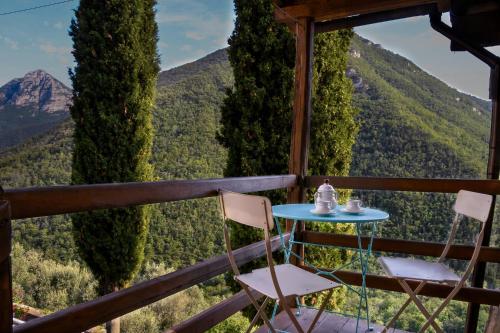 a table and chairs on a balcony with mountains in the background at Agriturismo Nonnamelia in Nasino