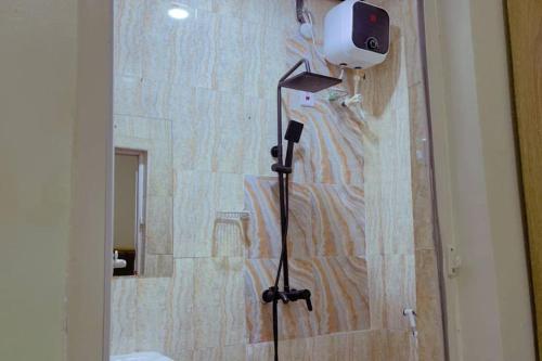 uma casa de banho com um chuveiro e uma câmara na parede em Homey 2-Bed-Apt 24HRS POWER & Unlimited Internet Access em Lagos