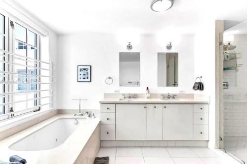 un bagno bianco con vasca e lavandino di WOW! Best Location! Best Unit! New Renovated South Beach Ocean Front a Miami Beach