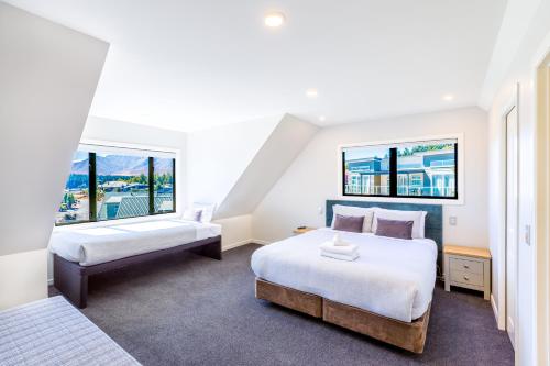 two beds in a room with two windows at Alpine Vista in Lake Tekapo