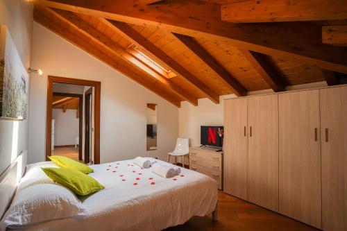 una camera da letto con un grande letto bianco e soffitti in legno di [Ortensia PentHouse] Leonardo Academy, MXP & Laghi a Sesto Calende