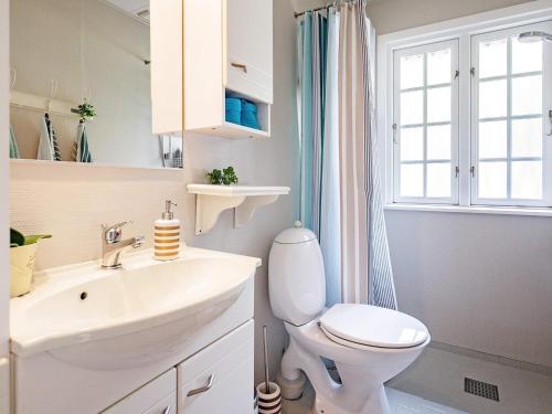 bagno con lavandino, servizi igienici e finestra di Holiday home Blåvand VI a Blåvand