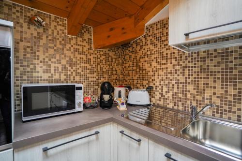 um balcão de cozinha com um micro-ondas e um lavatório em [Ortensia PentHouse] Leonardo Academy, MXP & Laghi em Sesto Calende