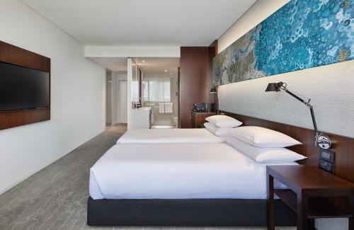 a hotel room with two beds and a tv at Hyatt Regency Brisbane in Brisbane