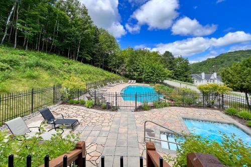 a backyard with a pool and a fence at L'Intemporel by Gestion ELITE in Mont-Tremblant