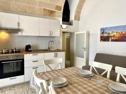 a kitchen and dining room with a table and chairs at Dimora Anna - Puglia Mia Apartments in Monopoli