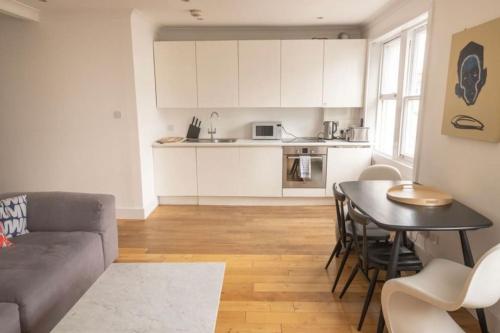 a living room with a couch and a table at Cool, Quiet Notting Hill 2 BED APT in London