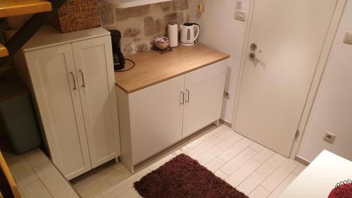 a small kitchen with white cabinets and a rug at Festa Apartments & Rooms in Dubrovnik