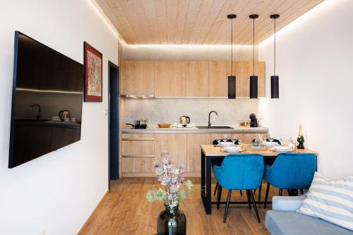 a kitchen and dining room with a table and blue chairs at TRI VODY Demänovská Dolina in Liptovský Mikuláš