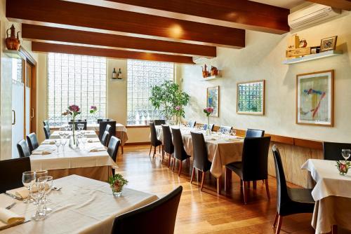 a dining room with white tables and chairs at Hotel Ristorante Costa in Costa Valle Imagna