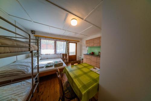Mały pokój z łóżkiem piętrowym i stołem w obiekcie Chatky Máj Máchovo jezero w mieście Doksy