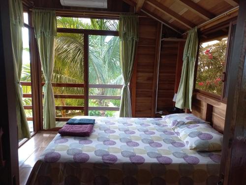 uma cama num quarto com uma grande janela em L'Oasis Don Juan em Don Juan