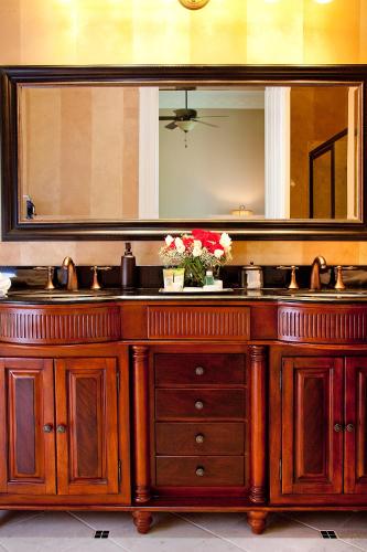 a bathroom with a wooden vanity with a large mirror at Riverside Inn Bed and Breakfast in Warsaw