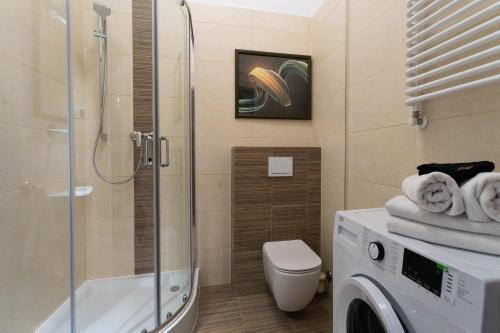 a bathroom with a shower and a washing machine at Apartament Inspirujący - z prywatnym monitorowanym parkingiem - 4 osobowy - Space Apart in Jelenia Góra