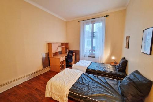 une chambre avec un lit, un bureau et une fenêtre dans l'établissement #EU Le 21 Dormoy, à Grenoble