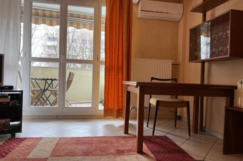 uma sala de estar com uma mesa e uma janela em Verdure Meylanaise #EV em Meylan