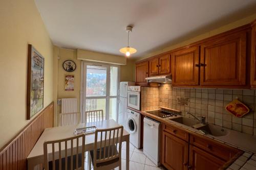 a kitchen with wooden cabinets and a sink and a dishwasher at #EV Le Taillat T3 for 4 in Meylan with Terrace in Meylan