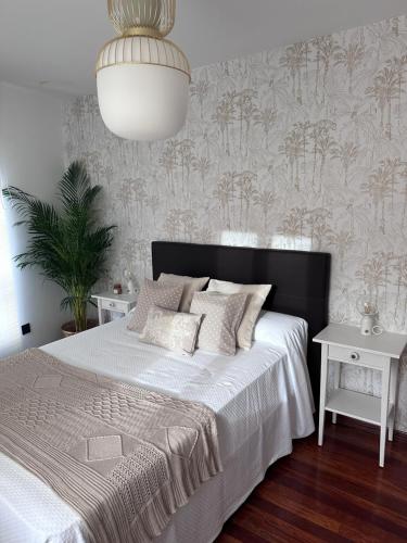 1 dormitorio con cama blanca y cabecero negro en La Austera, en Cudillero