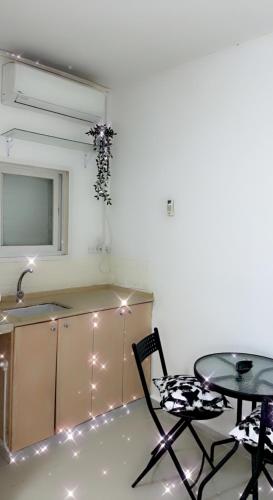 uma cozinha com uma mesa e cadeiras e um lavatório em Shanti Boutique em Netanya