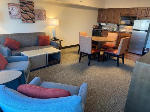 a living room with a couch and a table with chairs at Staybridge Suites Great Falls by IHG in Great Falls