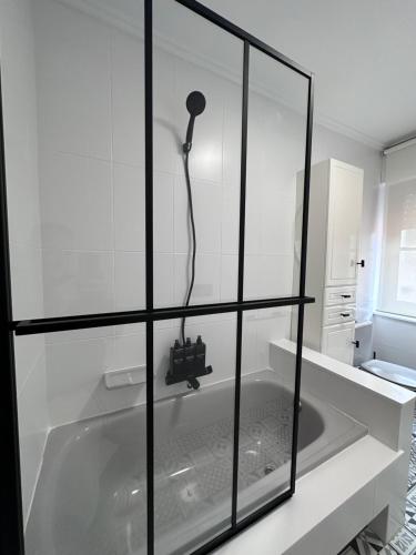 a bath tub with a shower in a bathroom at La Austera in Cudillero