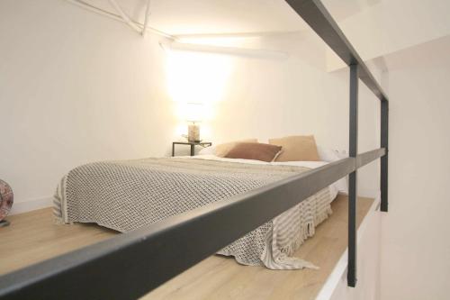 a bed in a white room with a metal bed frame at Loft de lujo a estrenar Apartamento n2 in Valencia