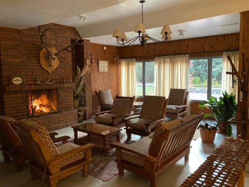 a living room with chairs and a fireplace at Estancia Quillen Lodge - Hosteria in Aluminé
