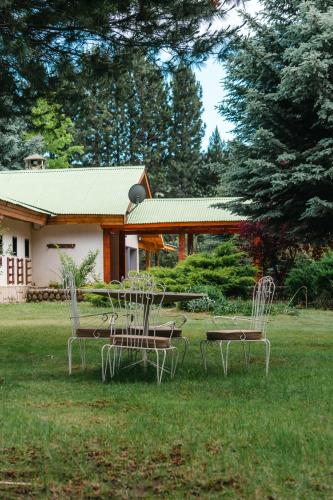 two chairs and a table in front of a house at Estancia Quillen Lodge - Hosteria in Aluminé