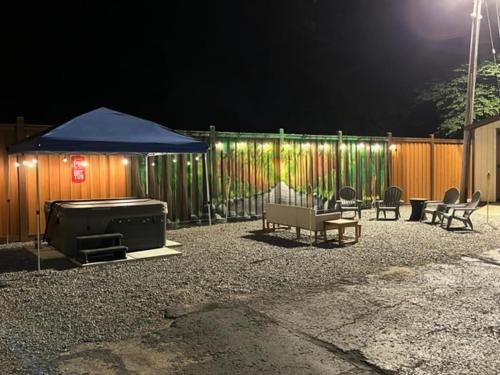 eine Terrasse mit einem Grill und einem blauen Regenschirm in der Nacht in der Unterkunft Benton Motel in Benton